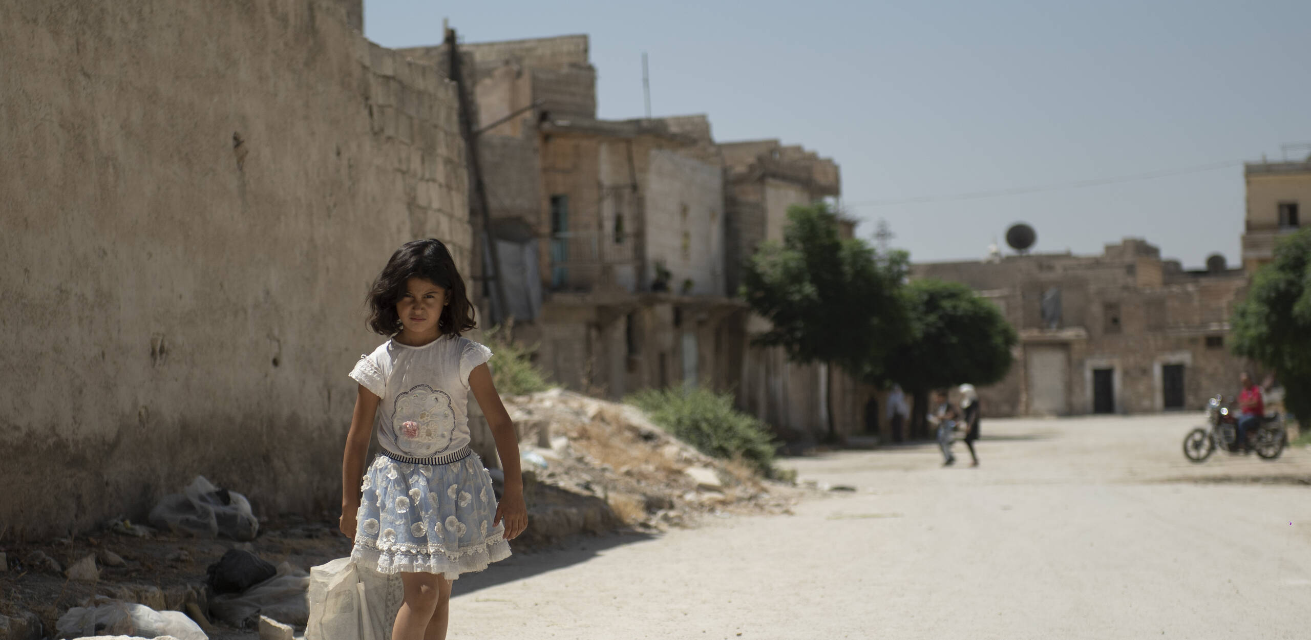 Une fillette syrienne traversant les rues dévastées d'Alep - le projet apporte une aide vitale aux familles vulnérables.