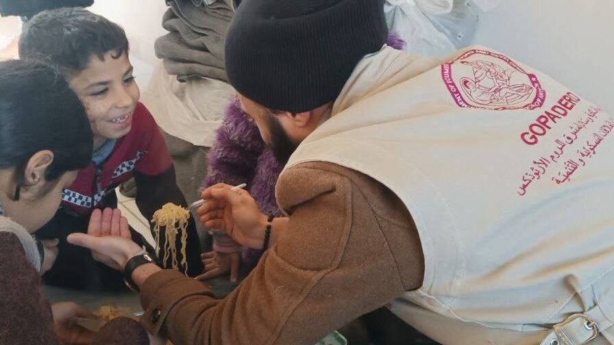 Un collaborateur de GOPA distribue de la nourriture à des enfants victimes du séisme.
