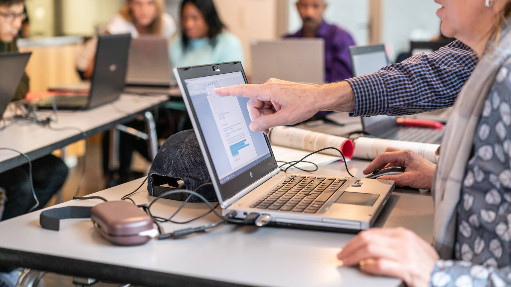 Un homme montre quelque chose à une femme sur son écran lors d'un cours d'informatique