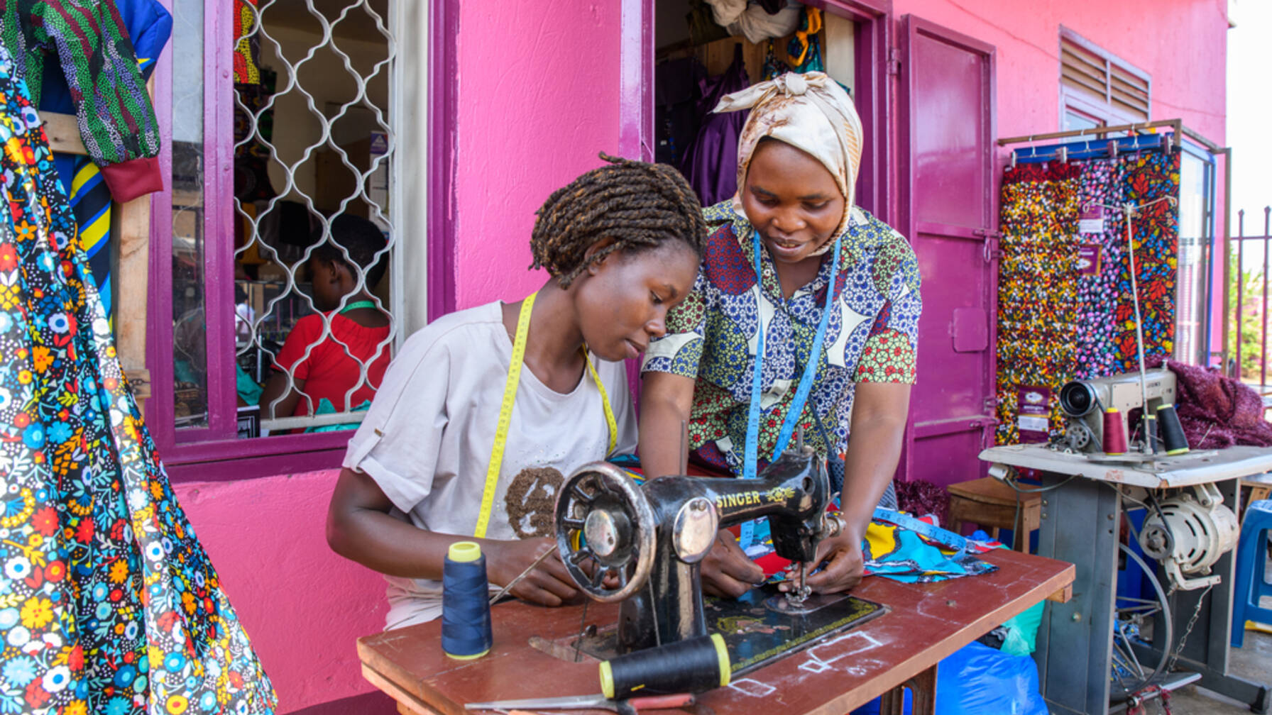 Tailor Iryn Nabagesera (29, right) from Uganda started her own business with the help of Caritas, and is now passing on her knowledge to other women.
