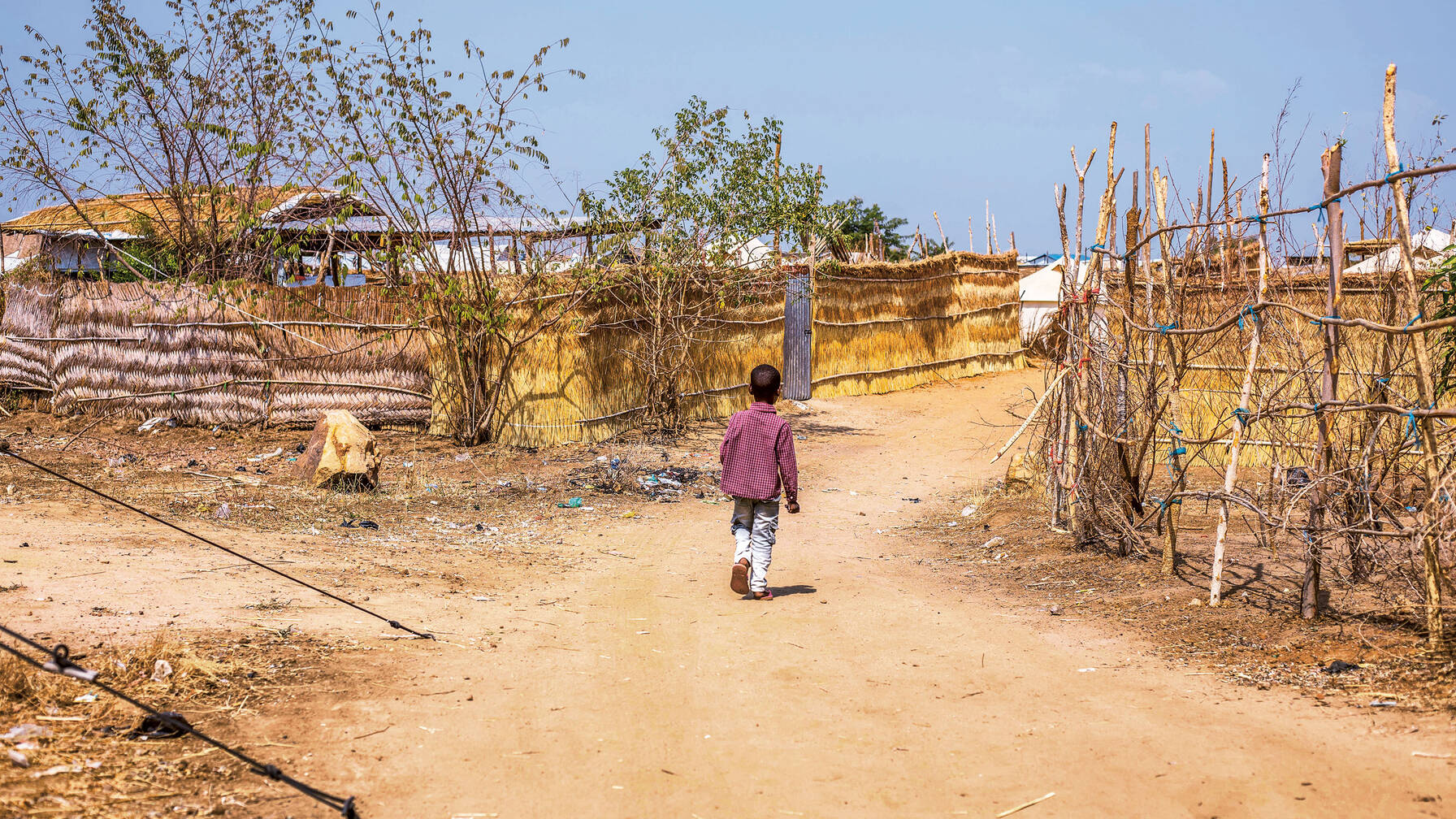 Malik attraversa il campo profughi fino al centro per bambini di Caritas dove si incontra con i suoi amici e dimentica il luogo inospitale.