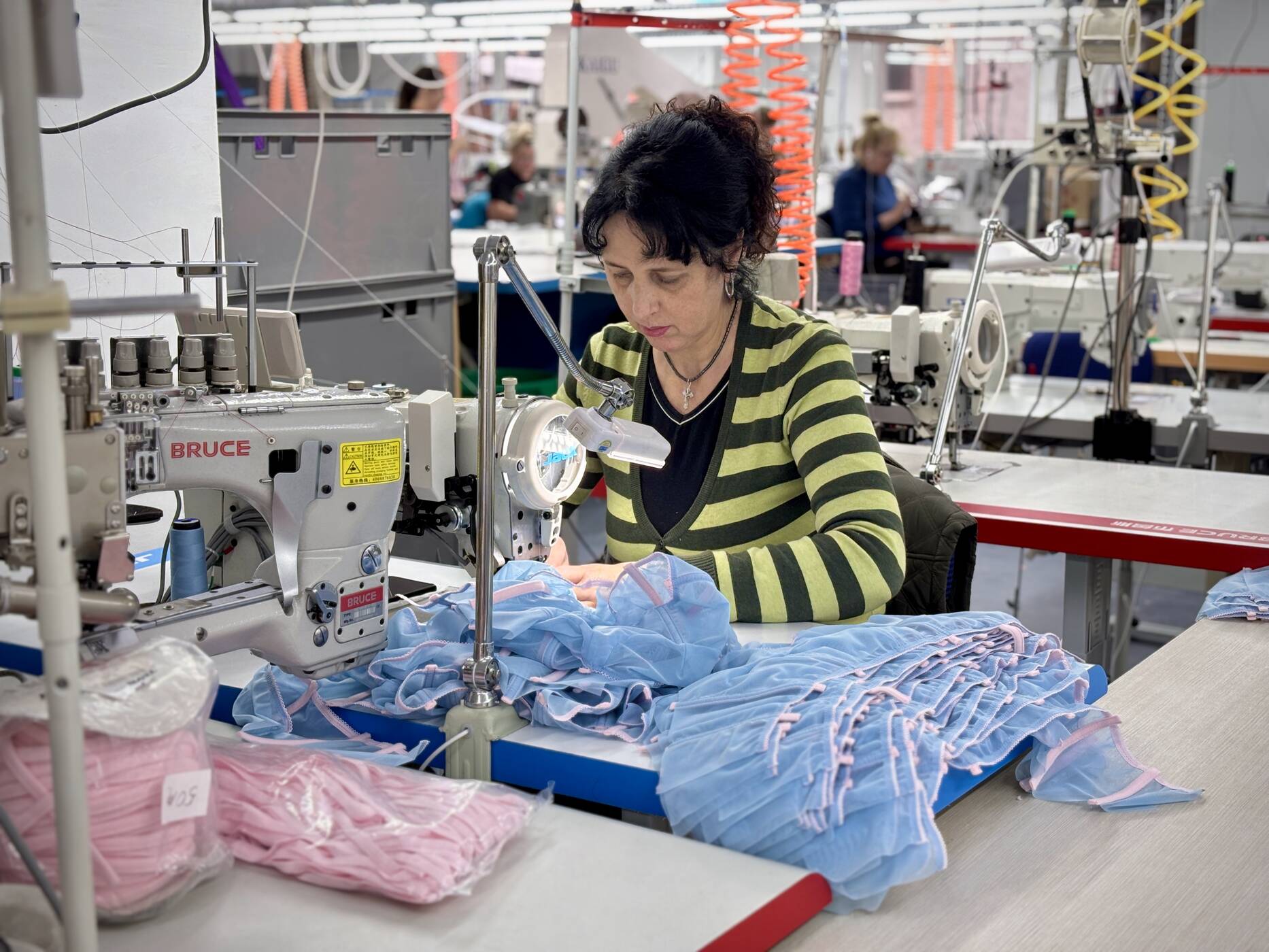 Eine Unternehmerin in der Ukraine näht ein Kleidungsstück in ihrem Studio