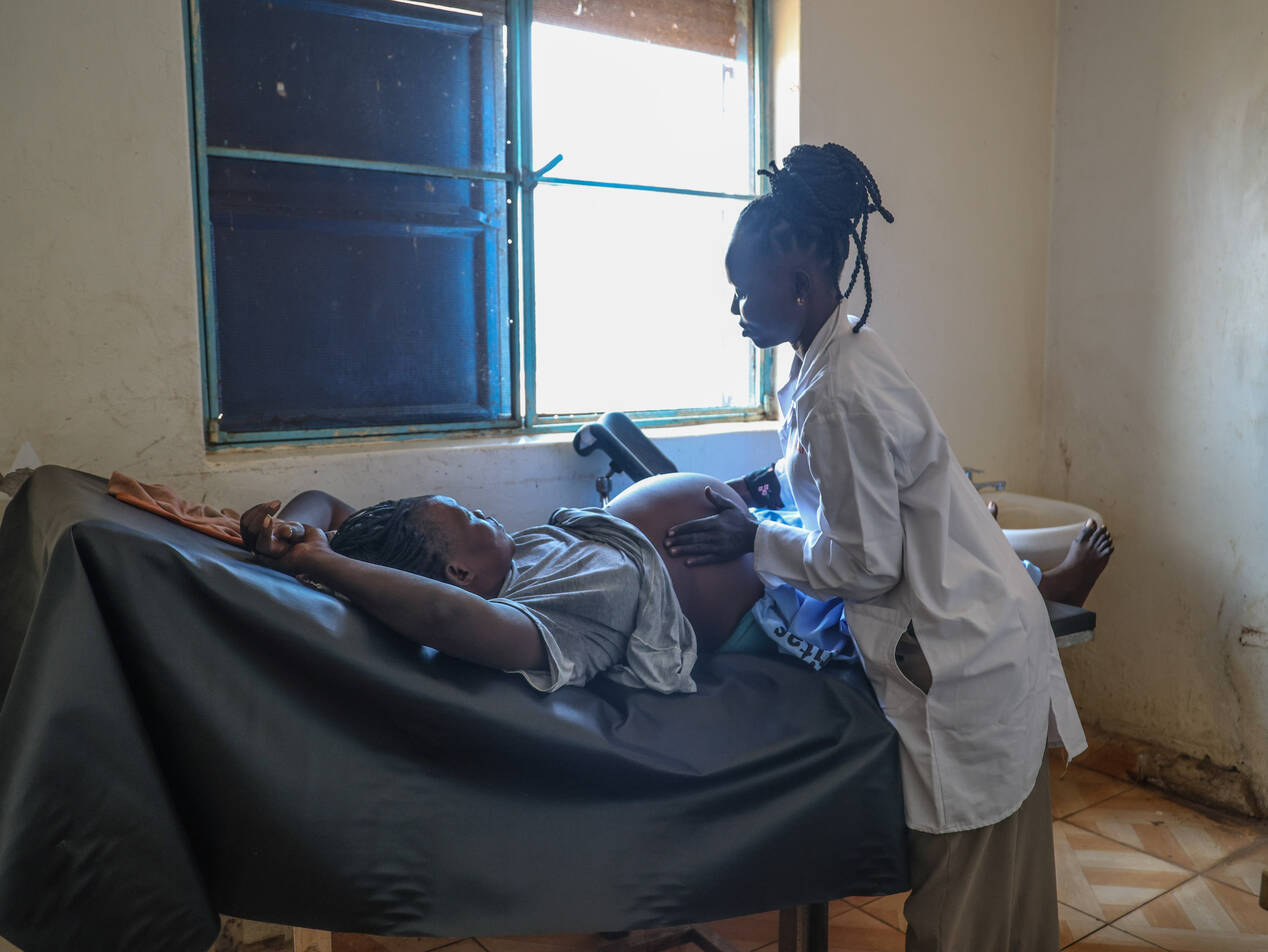 Die Hebamme Viola untersucht eine hochschwangere Frau in einem rudimentären Behandlungszimmer