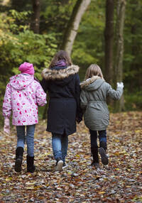 Una madre corre con i suoi due figli attraverso il bosco