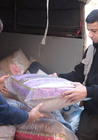 Ein Mitarbeiter der Caritas-Partnerorganisation Amel verteilt Decken an Geflüchtete aus dem Süden Libanons.