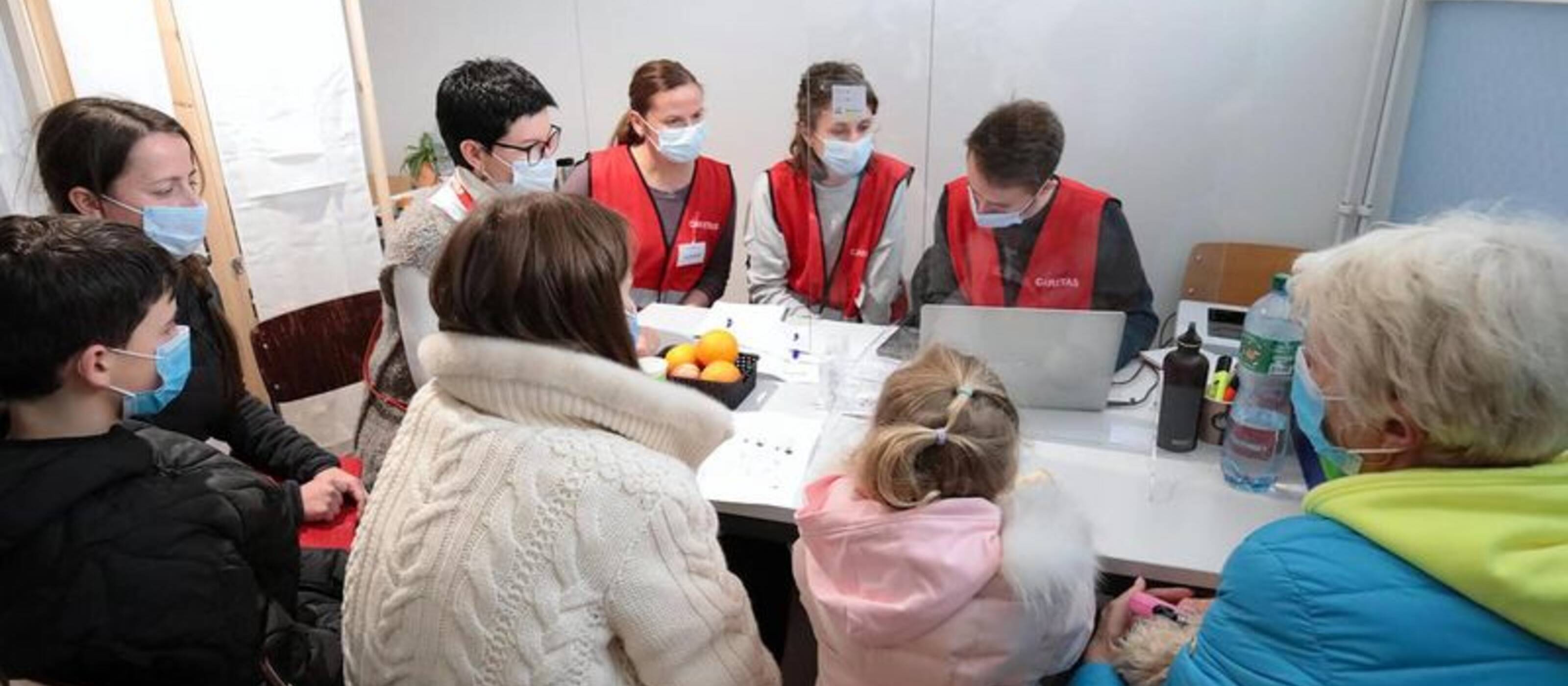 Des collaborateurs de Caritas Suisse enregistrent un groupe de réfugiés ukrainiens qui demandent le statut de protection S au centre fédéral de Boudry.