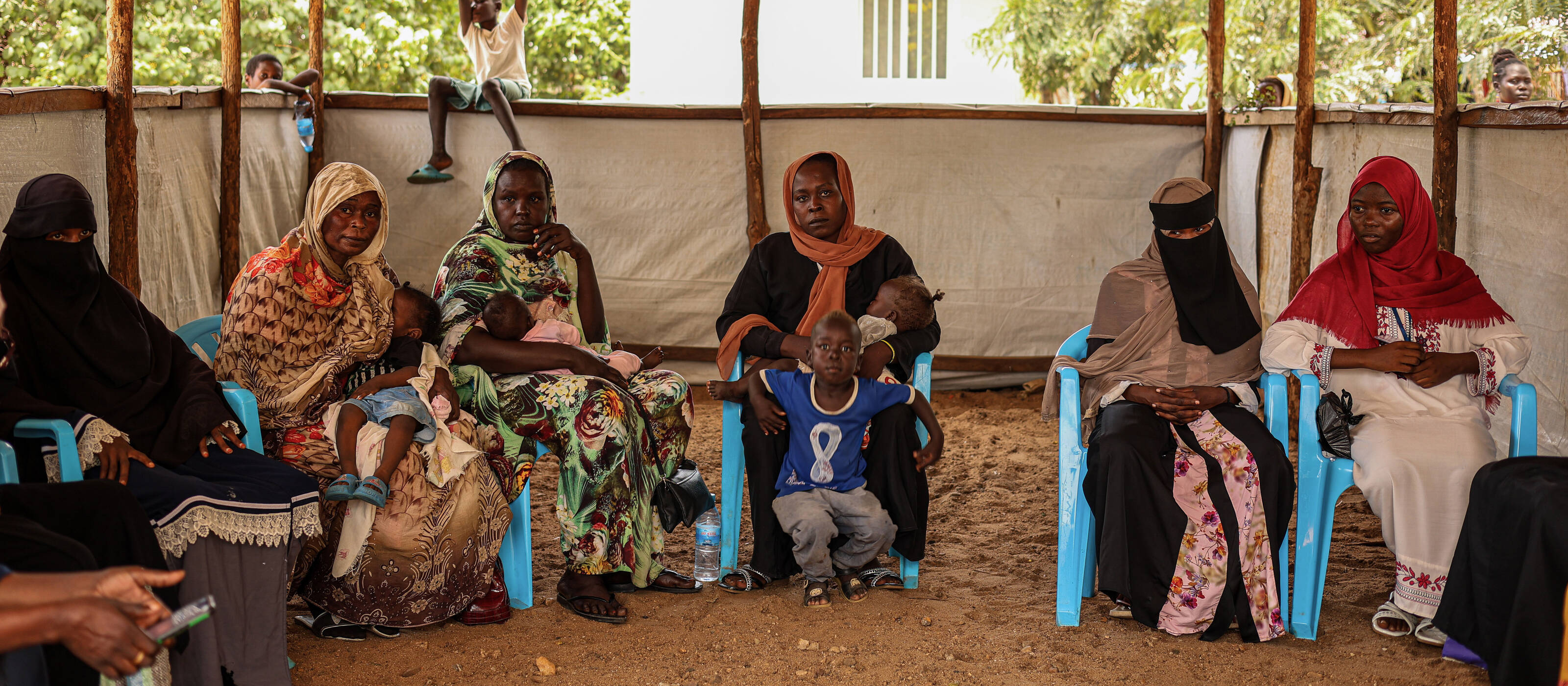 Women and children in a refugee camp in South Sudan take part in a community meeting.