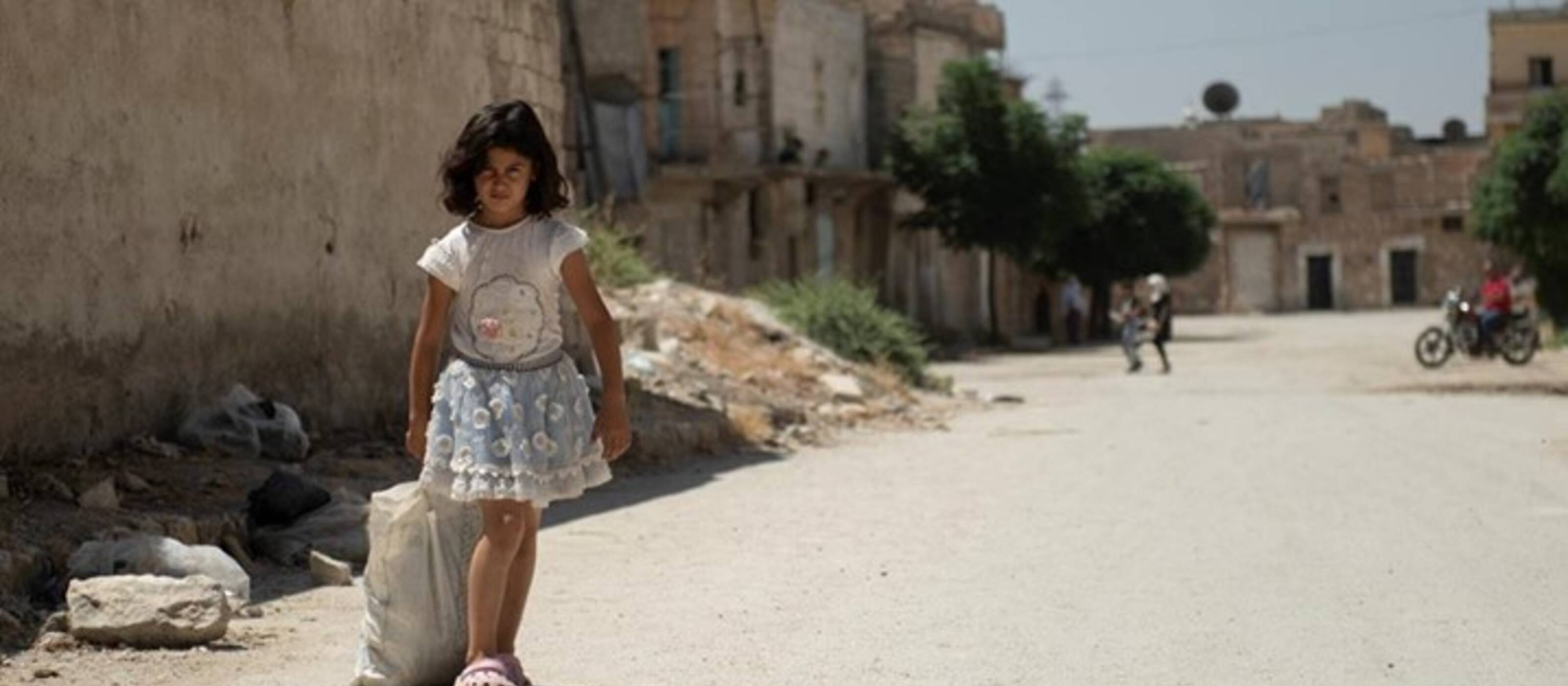 A Syrian girl on her way through the destroyed streets of Aleppo - the project supports vulnerable families with life-saving aid.