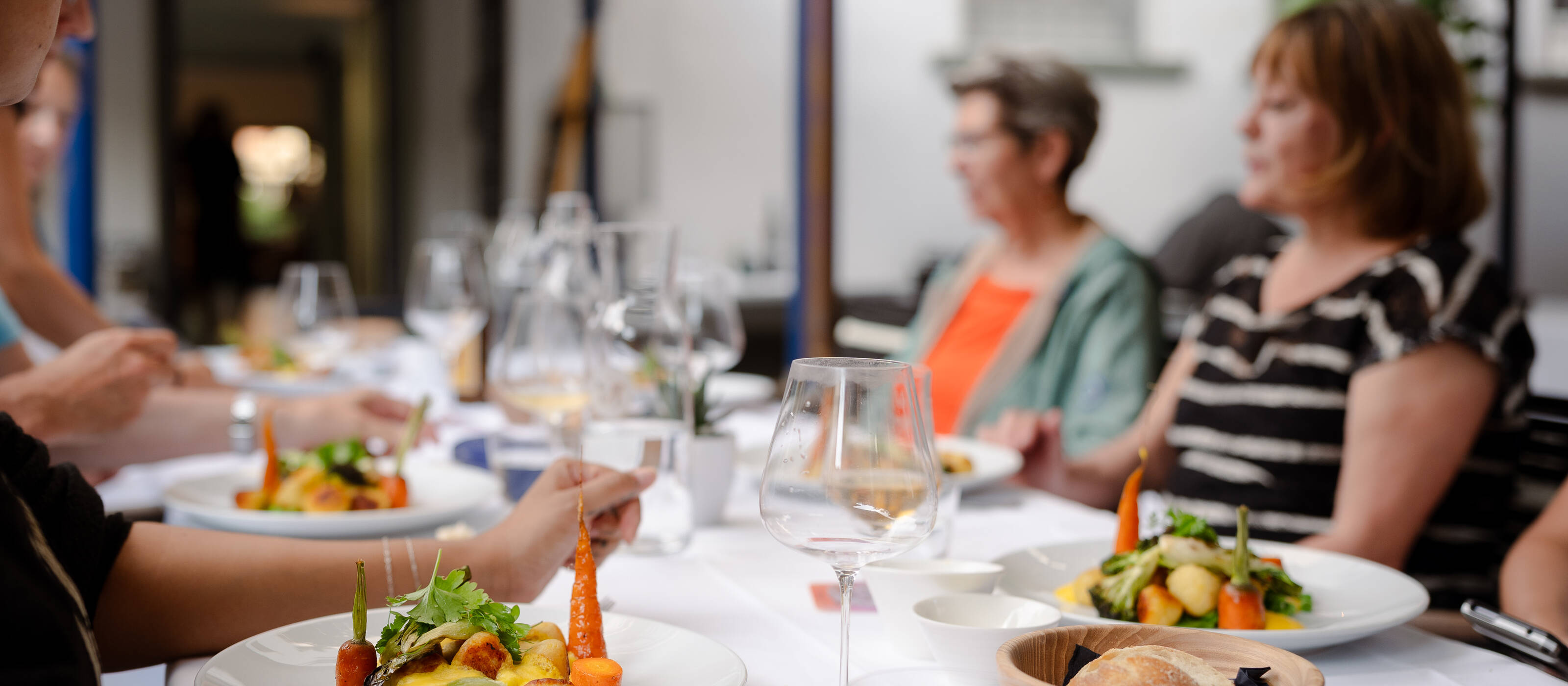 Bon‑Lieu‑Gutscheine ermöglichen armutsbetroffenen Menschen ein gemeinsames Essen in einem Gartenrestaurant.