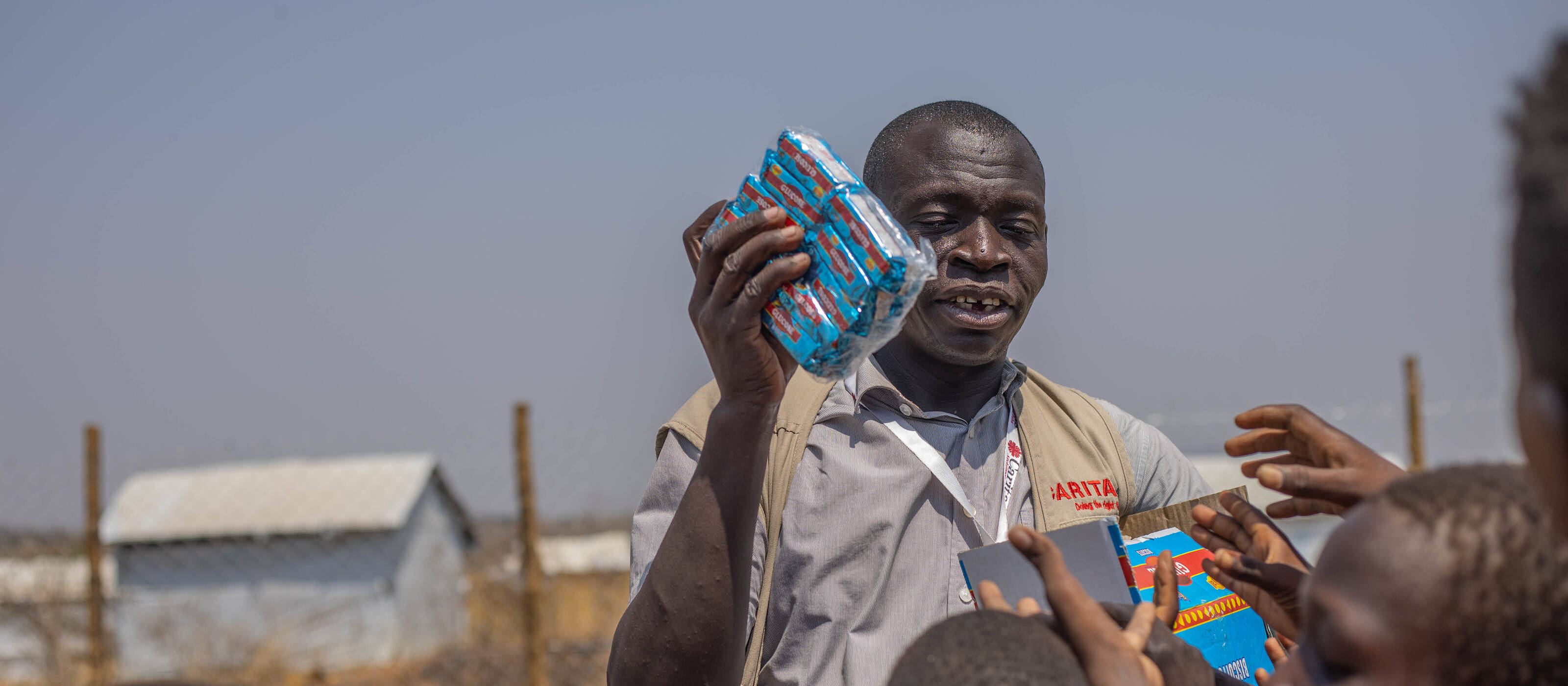 Un homme distribue des crackers aux enfants.