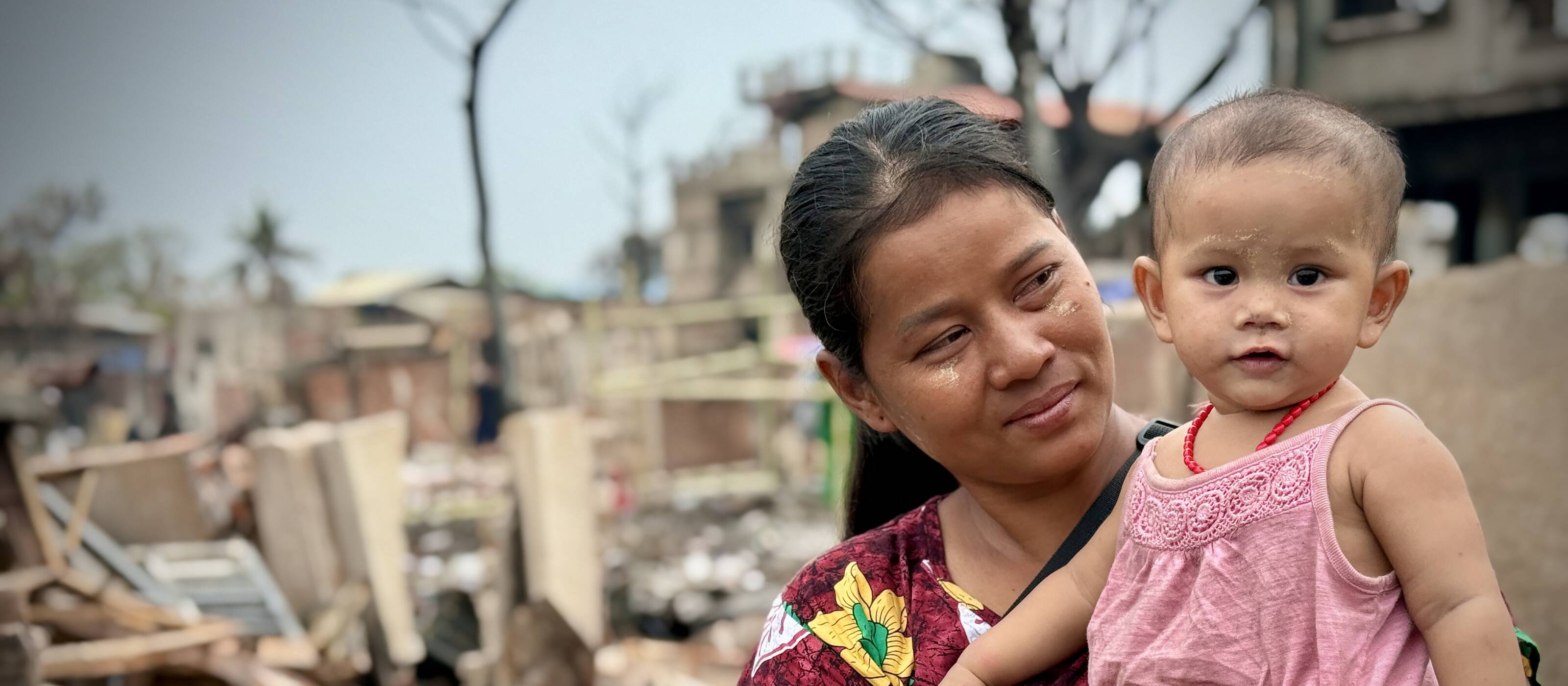 Auf dem Bild ist Kalaya mit ihrer Tochter vor den Trümmern nach dem Erdbeben in Myanmar zu sehen.