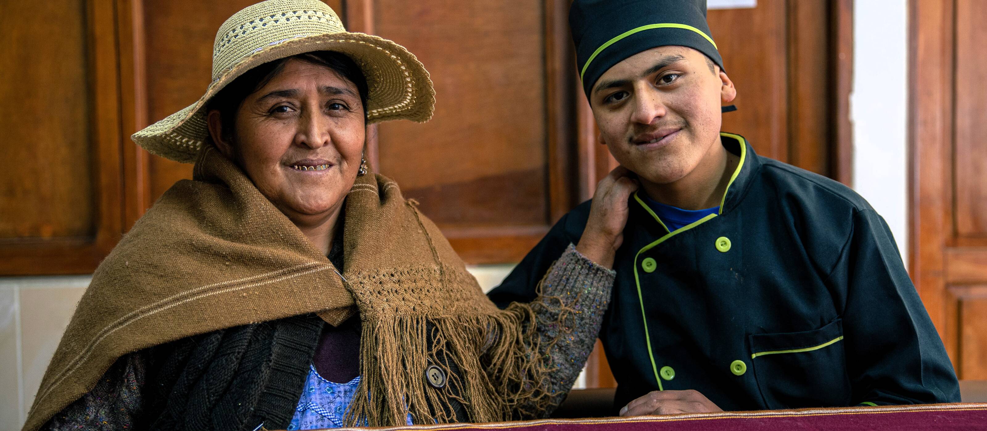 Un jeune homme et sa mère sourient à la caméra.