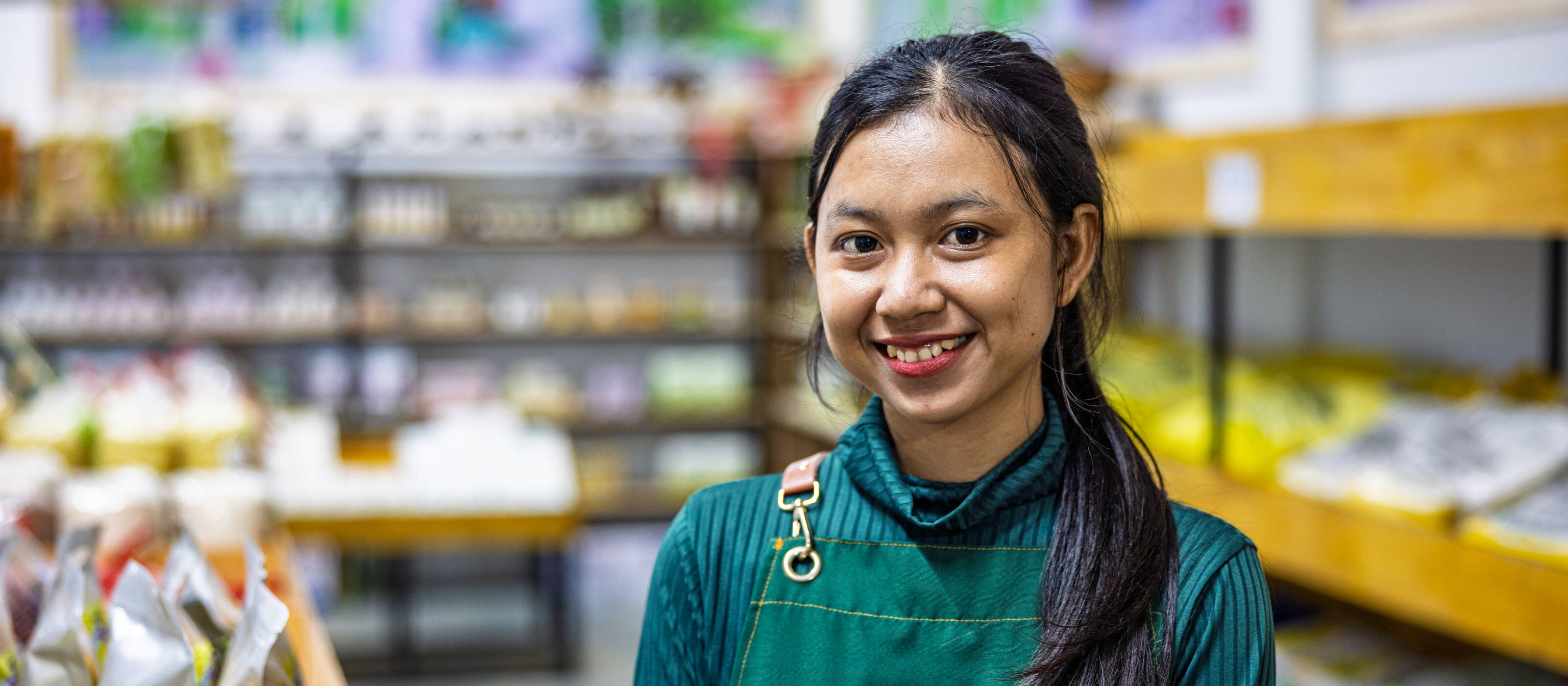 A young woman is standing in a grocery shop.