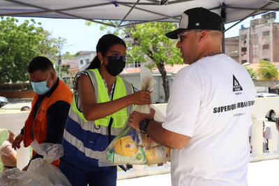 Frau gibt Lebensmittel an Mann ab in Venezuela